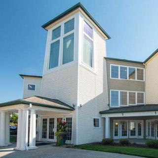 A modern residential building with large windows under a clear blue sky.