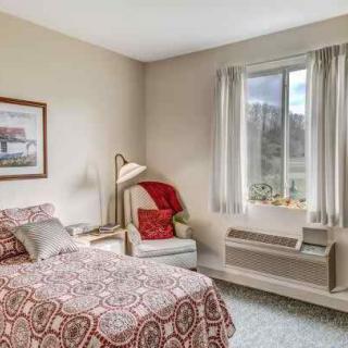 A cozy bedroom with a single bed and a window view.