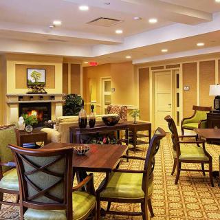 A cozy lounge area with comfortable seating, tables, and a fireplace.