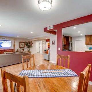 An open-concept home interior featuring a dining area, living room with a TV, and kitchen with hardwood flooring.