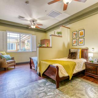 A cozy bedroom with a single bed, wooden flooring, and elegant decor.