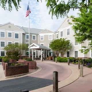 A large residential building with a pathway and flag in front.