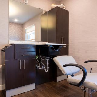 Interior of a modern beauty salon with a styling chair and sink.