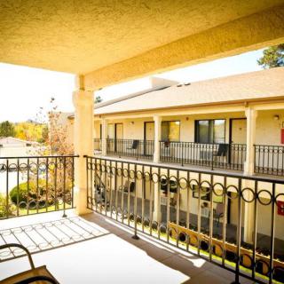 A sunny view from a hotel balcony overlooking neighboring rooms.