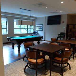 A cozy billiards room with a pool table and seating area.