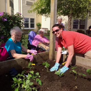 A group of people enjoying gardening together in an outdoor community setting.