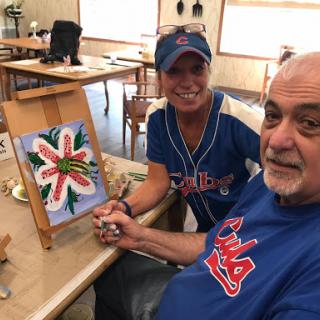 A joyful moment shared as a couple enjoys painting together.