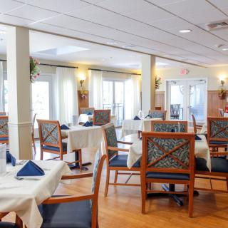 An elegant dining area with neatly set tables and chairs, featuring a bright and welcoming atmosphere.