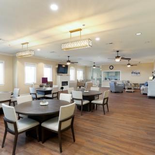 A spacious and well-lit dining area with modern furniture and wooden flooring.