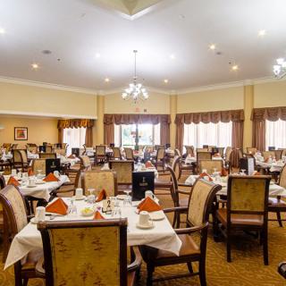 An elegant dining room with neatly arranged tables and chairs, ready for guests.