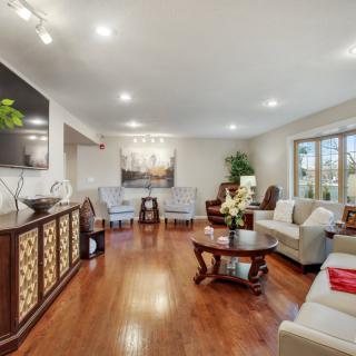 A spacious and elegantly decorated living room with comfortable seating and hardwood flooring.