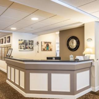 A modern reception area with artwork on the walls and a decorative clock.