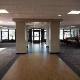 A spacious lobby area showcasing an entrance with large windows and seating arrangements.