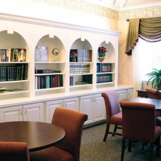 A cozy reading room with a built-in bookshelf and comfortable chairs.