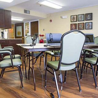 A conference room with a large table and multiple chairs arranged for a meeting.