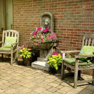 A cozy outdoor patio with wooden chairs and vibrant flowers.