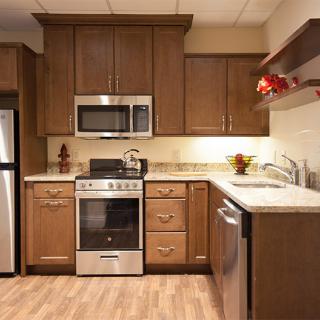A modern kitchen with wooden cabinets and stainless steel appliances.