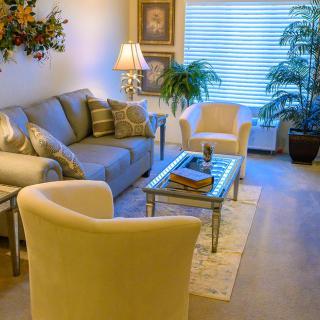 A cozy and elegantly decorated living room with comfortable seating and indoor plants.