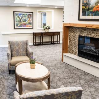 A cozy living room with a fireplace, artwork on the walls, and comfortable seating.