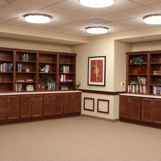 A quiet library space with wooden bookshelves and artwork on the wall.