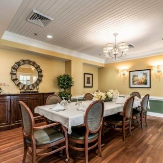 A well-lit dining room with a set table and elegant decor.