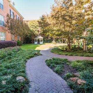 A winding pathway through a landscaped garden area next to a building.