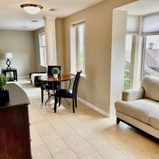 A modern living room with natural light, featuring a sofa and dining area.