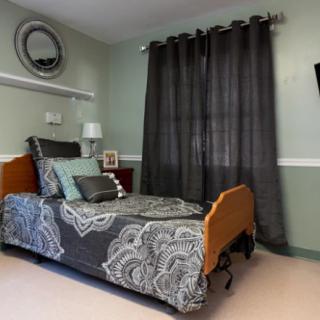 A well-decorated bedroom with a hospital-style single bed, gray curtains, and modern decor.