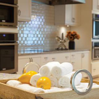 A modern kitchen with a countertop display of lemons and white towels.