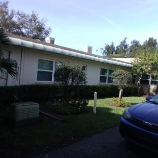 A view of a suburban house with a well-kept garden and parked car.