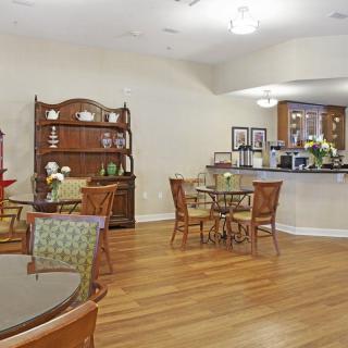 A cozy cafe interior with wooden tables and chairs, complemented by elegant decor and warm lighting.