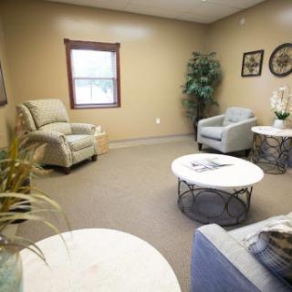 A cozy waiting room featuring comfortable seating and decorative plants.