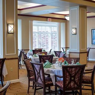 A well-lit dining area with neatly arranged tables and chairs.