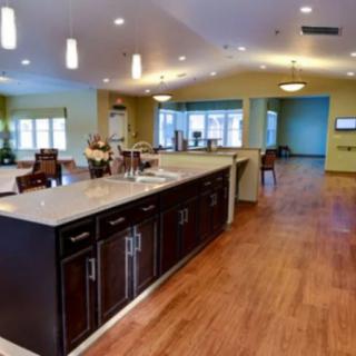 A modern kitchen with an island counter and wood flooring, featuring an open and contemporary design.