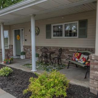 A welcoming front porch with outdoor seating and decorative plants.