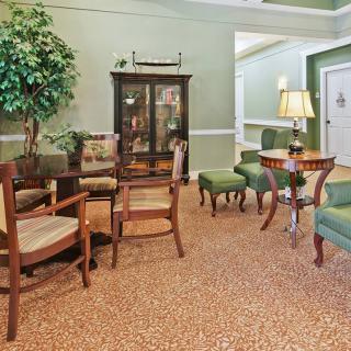 A traditional living room with wooden furniture and green accents.