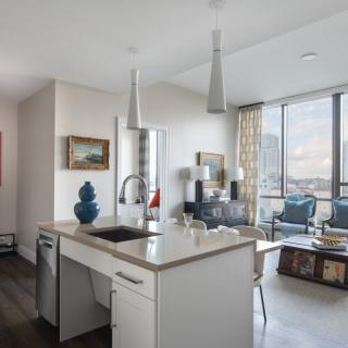 A modern open-concept apartment with a bright kitchen and living area.