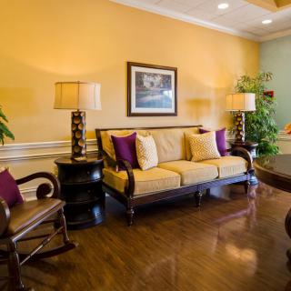 A cozy living room with a yellow sofa, decorative pillows, and elegant furnishings.