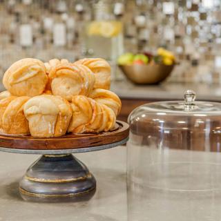 A display of freshly baked muffins on a cake stand in the kitchen.
