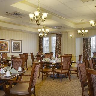 A well-decorated dining room with elegant chandeliers and neatly arranged tables.
