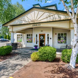 A welcoming building entrance surrounded by trees and well-maintained landscaping.
