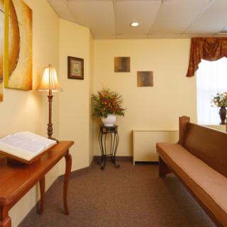 A cozy waiting room featuring warm colors, comfortable seating, and decorative elements.