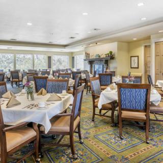 A well-arranged dining room with neatly set tables and chairs in a formal setting.