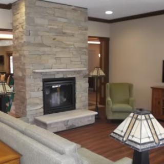 A cozy living room featuring a stone fireplace and comfortable seating.