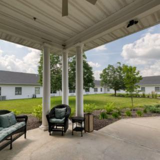 A cozy patio with outdoor seating and a garden view on a sunny day.