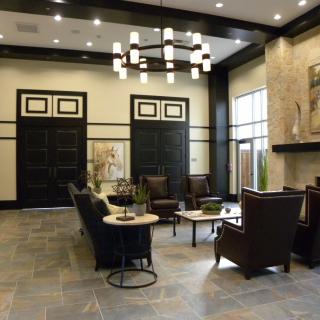 A modern lobby with stylish furniture and a central chandelier.