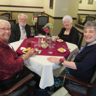 A group of seniors enjoying a meal together at a dining table.