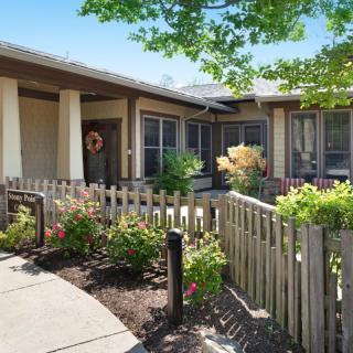 A charming house with a garden and wooden fence on a sunny day.