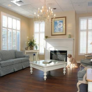 A cozy living room with elegant dcor, featuring a chandelier, fireplace, and comfortable seating.