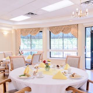 A beautifully arranged dining room with elegant table settings and ample natural light.